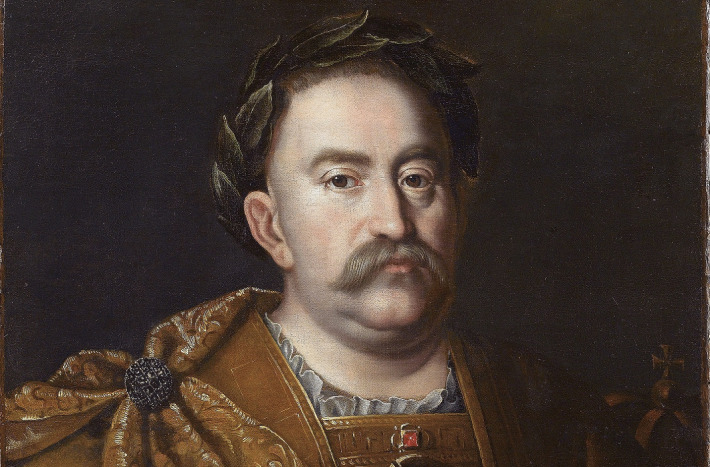 Obraz przedstawia portret króla Jana III Sobieskiego. Król ukazany w wieńcu na głowie. Widać fragment zbroi i złotego płaszcza. Omawiany fragment pokazuje jego twarz, poważną, dostojną z długim wąsem.