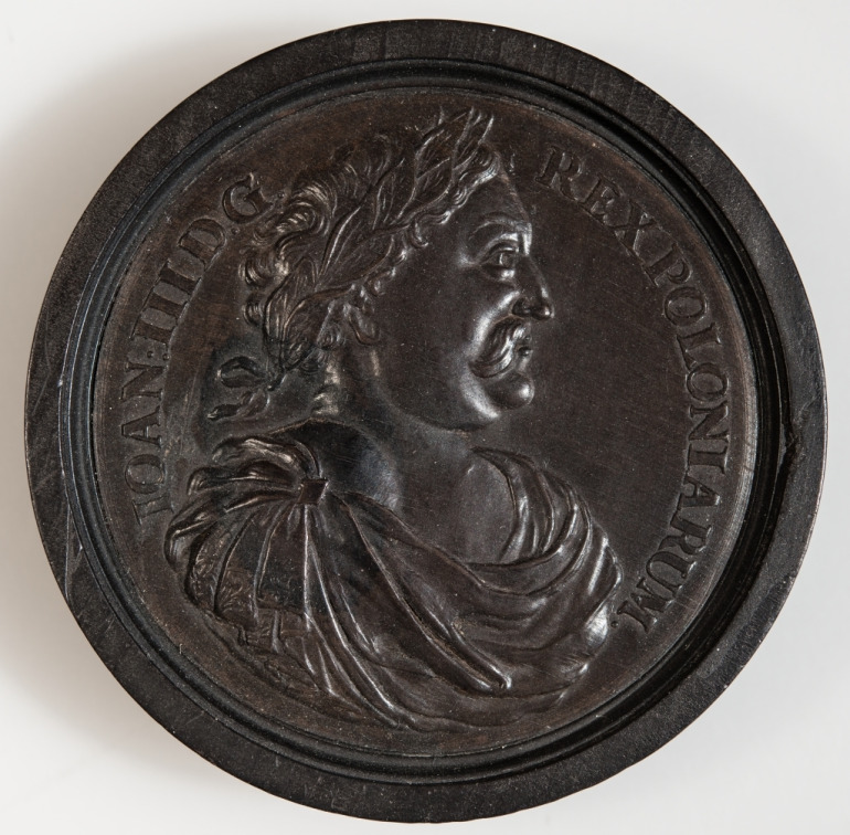 Pionek do gry z portretem Jana III Sobieskiego. Jest to jeden z pięciu zachowanych w kolekcji Bayerisches Nationalmuseum pionków do gry z portretami europejskich władców. Na awersie odciśnięty wizerunek polskiego króla, w profilu, w stroju antycznym i wieńcu laurowym. Wokół inskrypcja: IOAN:III D.G. REX POLONIARUM.