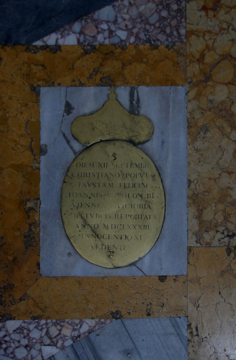 Linea Clementina w rzymskim kościele Santa Maria degli Angeli e dei Martiri jest przyrządem do precyzyjnego wyznaczania astronomicznych pór roku. Zbliżenie na fragment ściany lub posadzki na której znajduje się złota, obła płaszczyzna z koroną i napisem po włosku. 