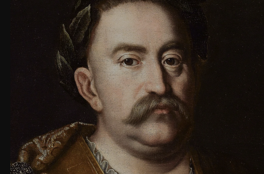 Portret olejny króla Jana III Sobieskiego. Król patrzy poważnie przed siebie. Ma na głowie wieniec laurowy, ubrany jest w zbroję antyczną.